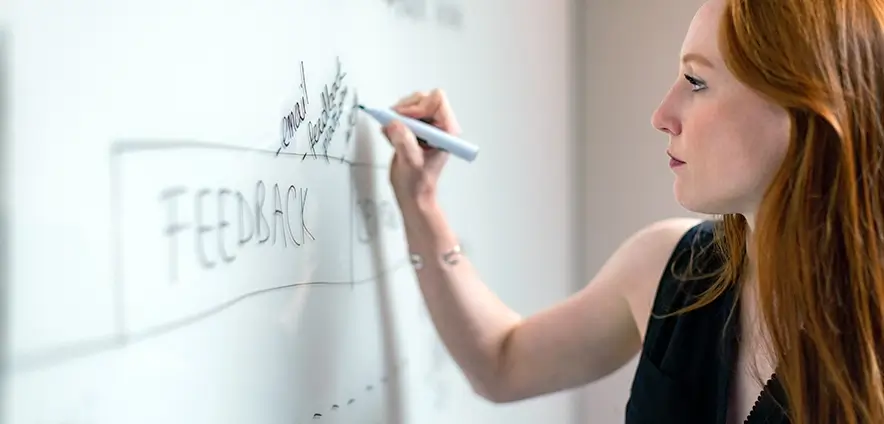 A women is writing on glass whiteboard